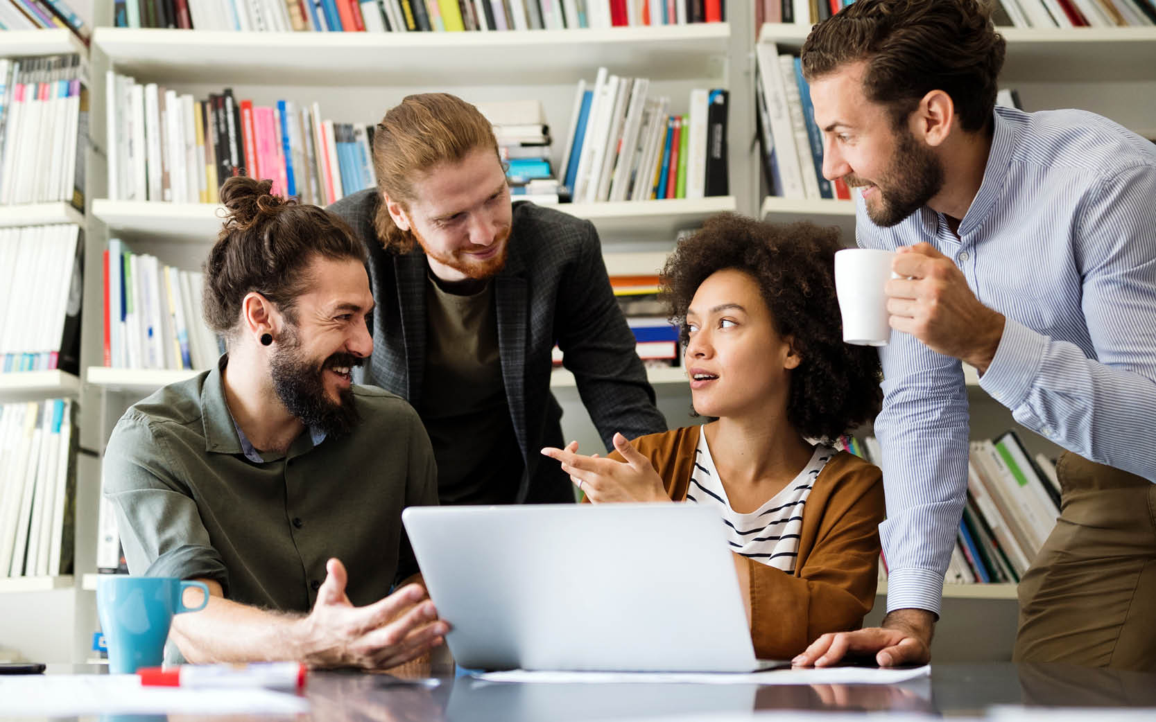 office workers sitting around open aptop talking