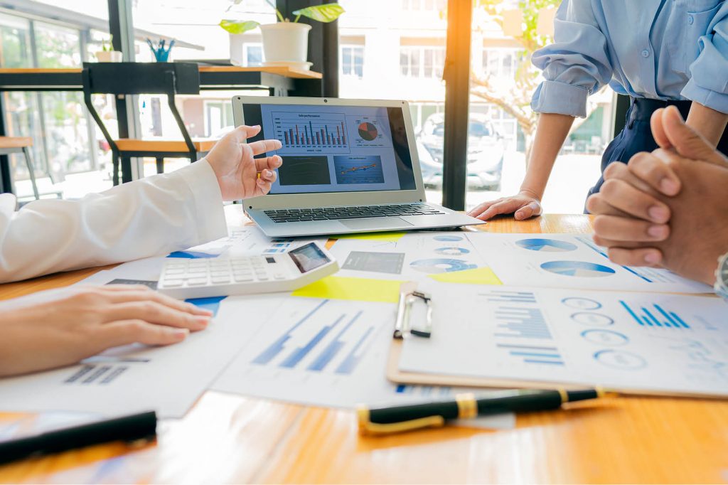 office workers reviewing expenditure on laptop