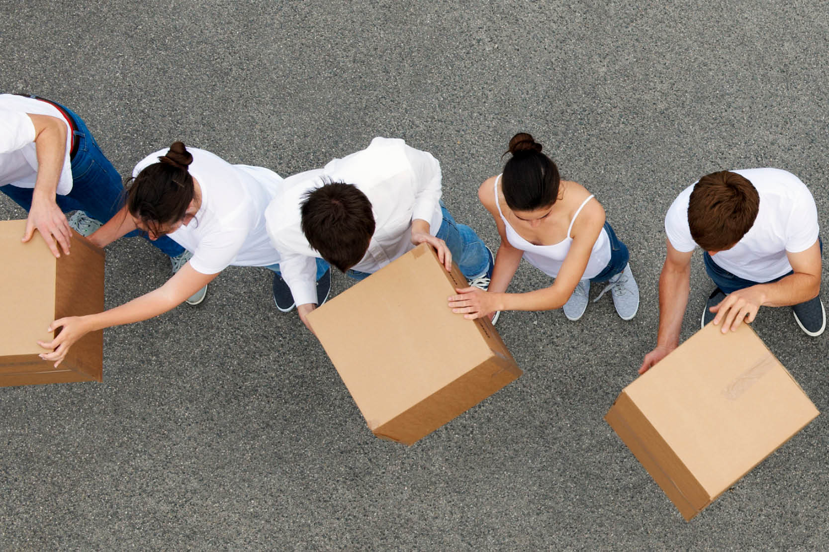 people passing cardboard boxes in a line